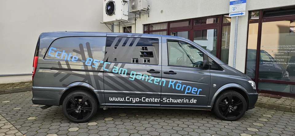 Grauer Van mit türkisfarbener Beschriftung und großem Schneeflockenmotiv