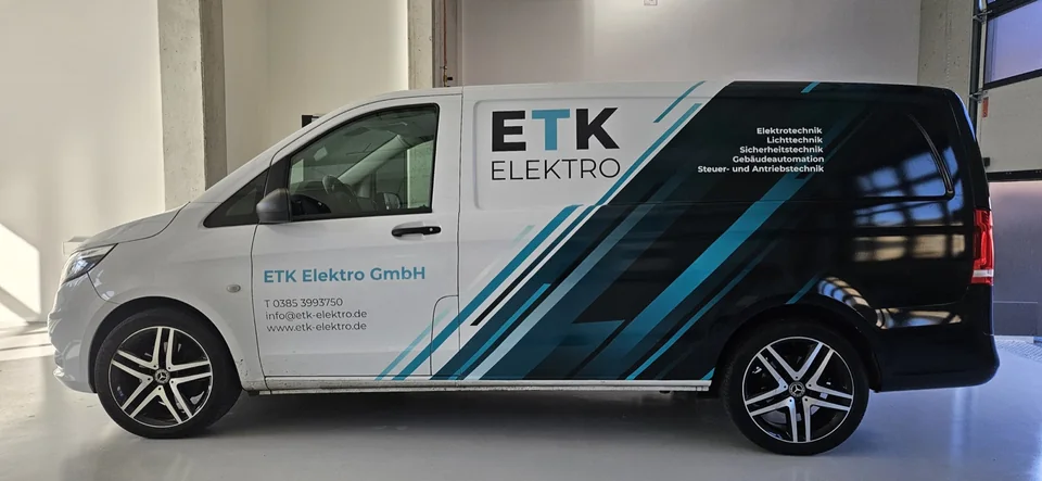 Weißer Firmenvan mit schwarzen und türkisfarbenen Diagonalen und ETK-Elektro-Logo