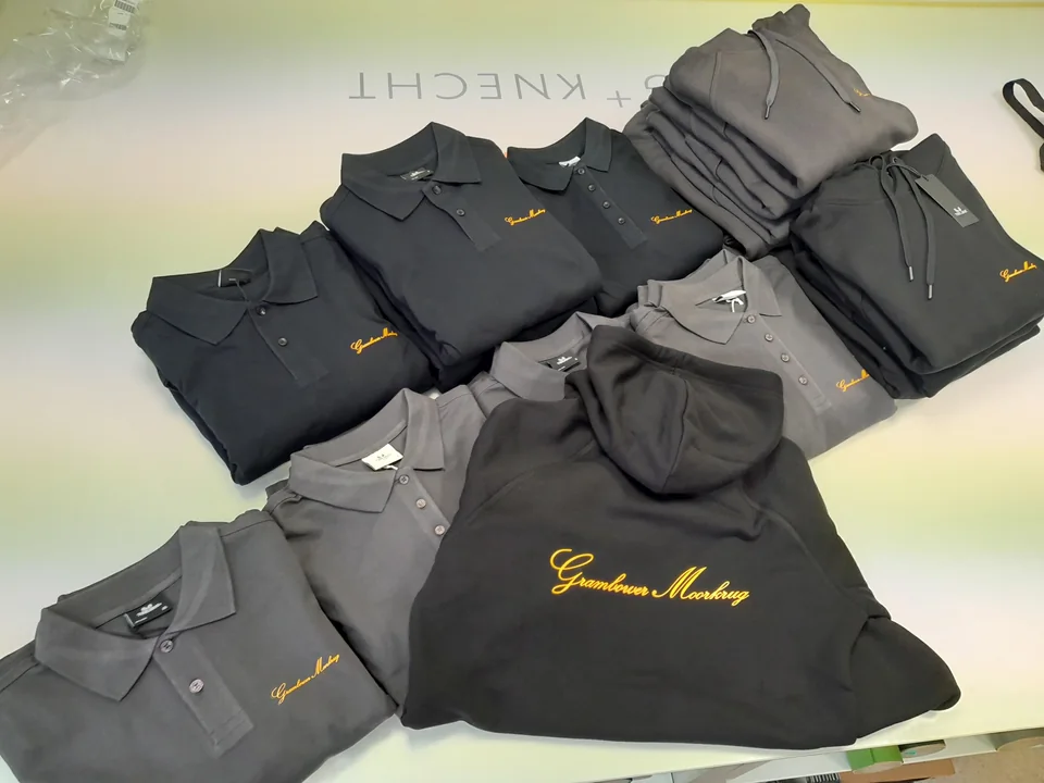 Graue und schwarze Poloshirts und Hoodies mit gelbem Schriftzug